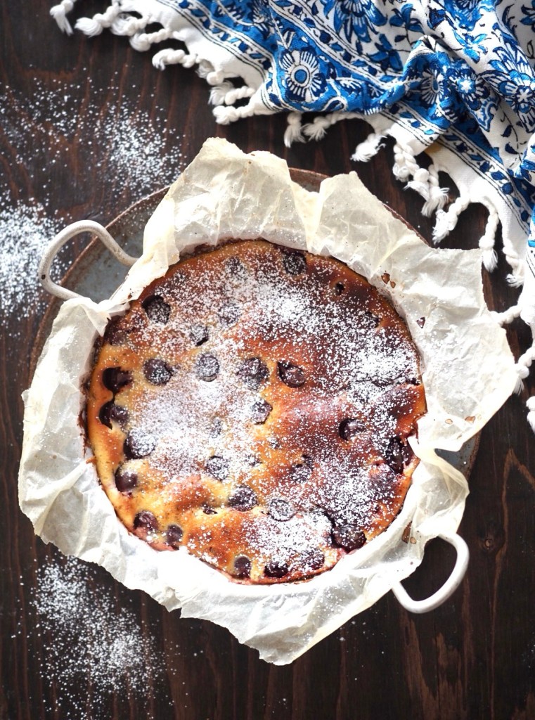 Clafoutis eli ranskalainen pannukakku vuoassa, pinnalla marjoja ja tomusokeria