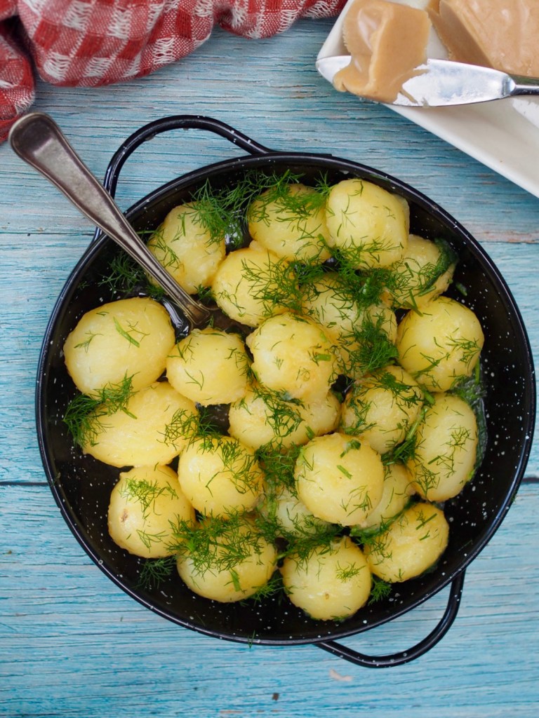 Keitetyt uudet perunat ruskistetulla voilla ja tillillä kulhossa